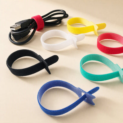 Softbind – Open hook-and-loop loops in white, yellow, red, black, green and blue, with a red tie bundling a USB cable