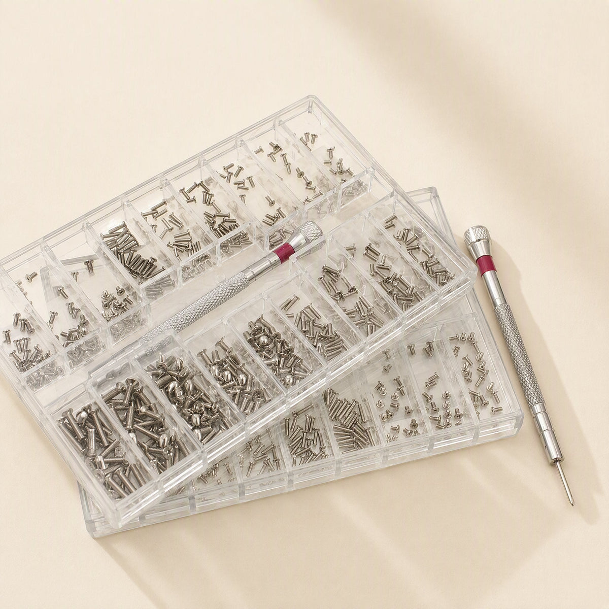 Microbite micro cross-head self-tapping screws in two clear compartment boxes beside a red-banded screwdriver