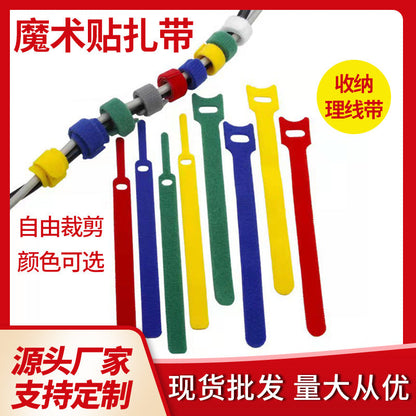 Catstrap Cable Ties in red, blue, green and yellow, with strips of varying lengths and colored loops on a cable