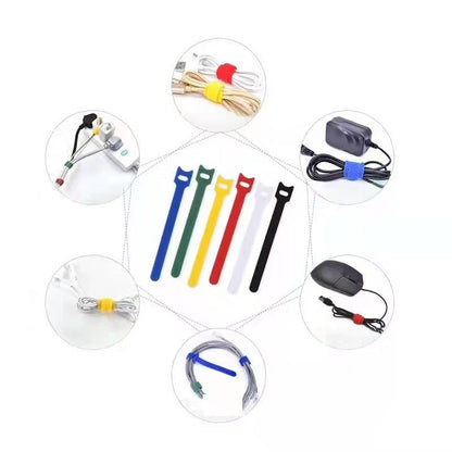 Catstrap – Six T-shaped straps in blue, green, yellow, red, white and black, surrounded by cables, a mouse and a charger