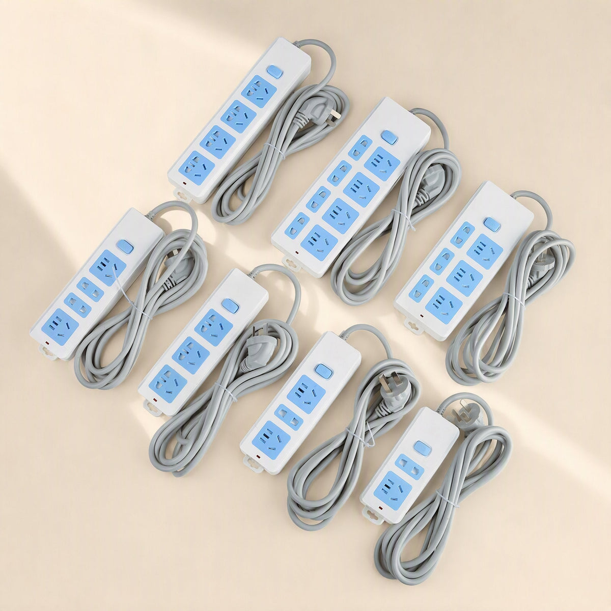 Cordcraft – Seven white and blue power strips with coiled grey cords in varied socket layouts, seen from above