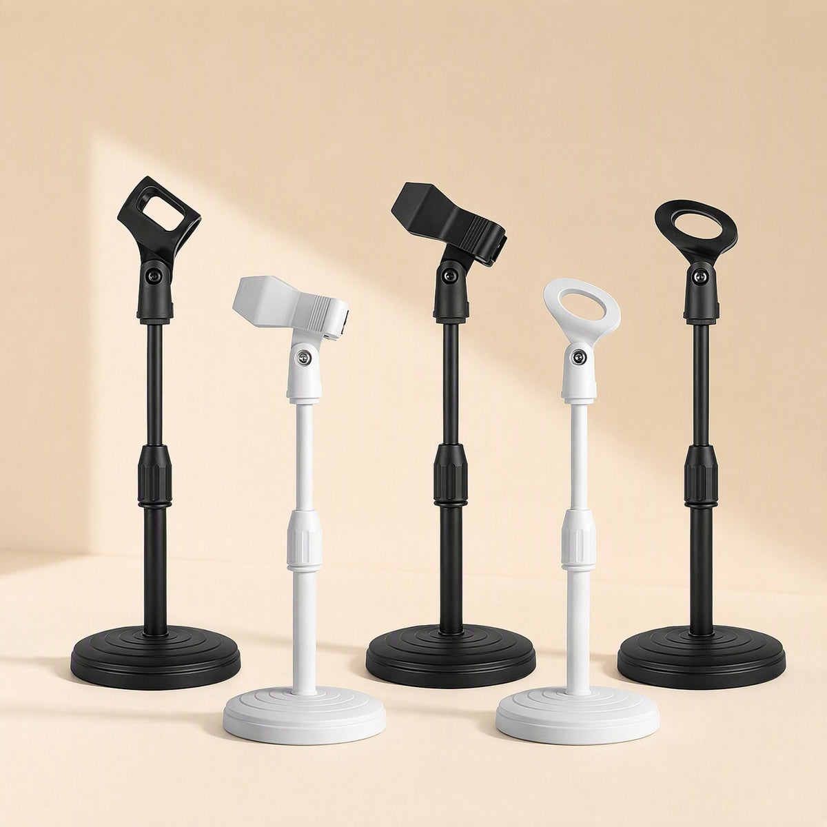Voicelift Desktop Microphone Stand in black and white with three clip styles on a beige backdrop