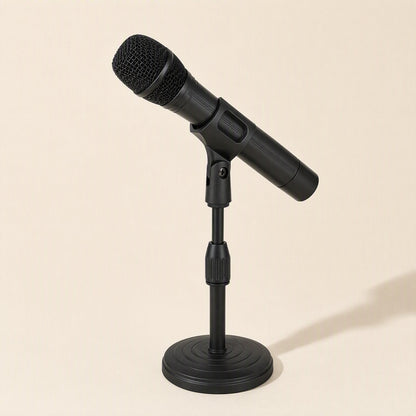 Voicelift – Black handheld microphone held in the clip of a round-based desktop stand against a cream background