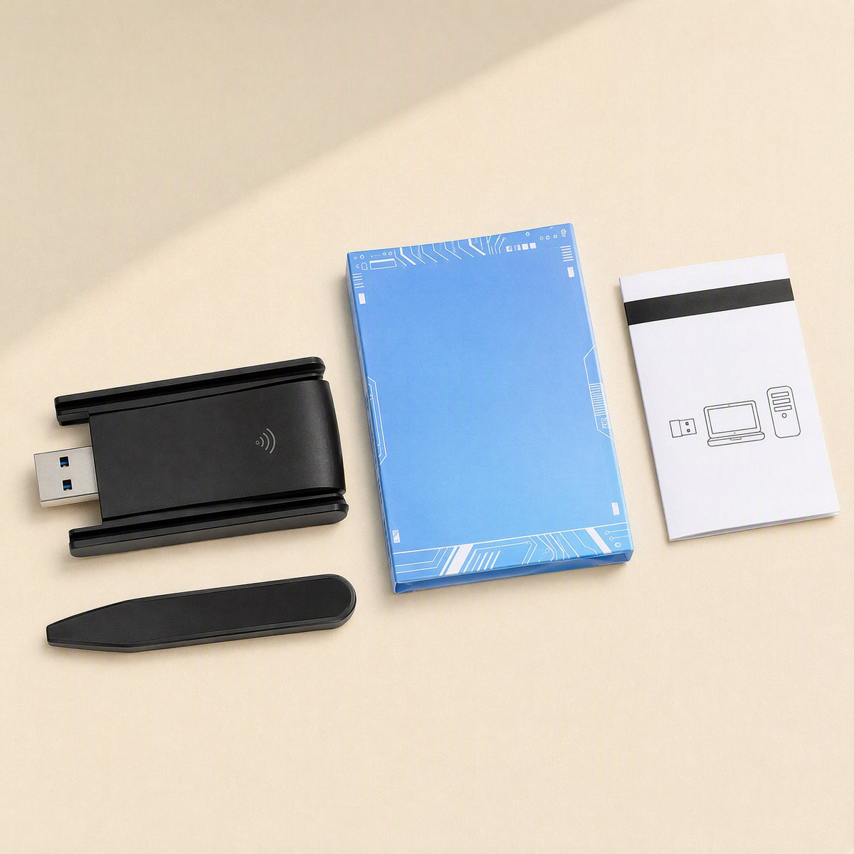 Twinsignal – Black USB adapter with antennas folded flat, beside a blue retail box, a manual and a stand piece