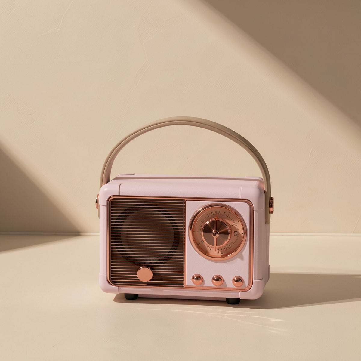 Oldchime Retro Bluetooth Speaker in pink with a tan leather handle, front view in soft window light