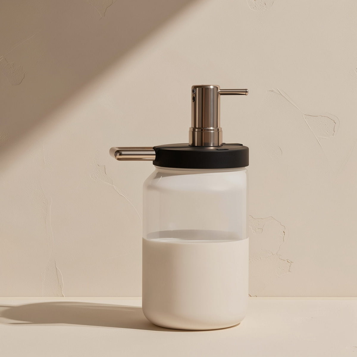 Flashport – Frosted glass jar with a black lid and chrome pump dispenser, half full of white liquid, on a cream surface