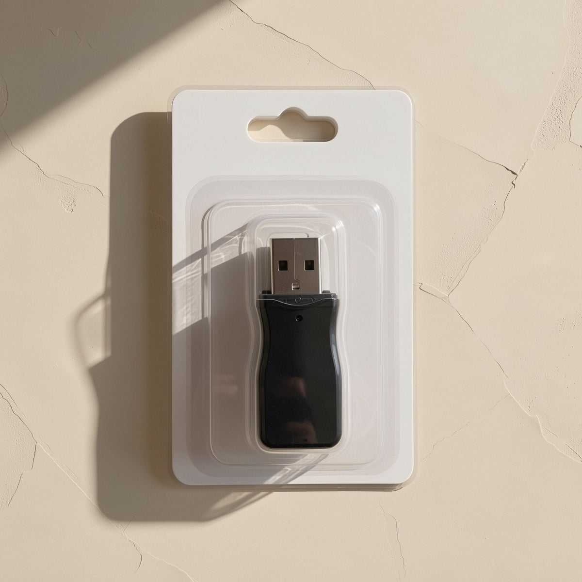 Flashport – Black USB card reader in clear plastic blister packaging with a hang hole, seen from above on a cream surface