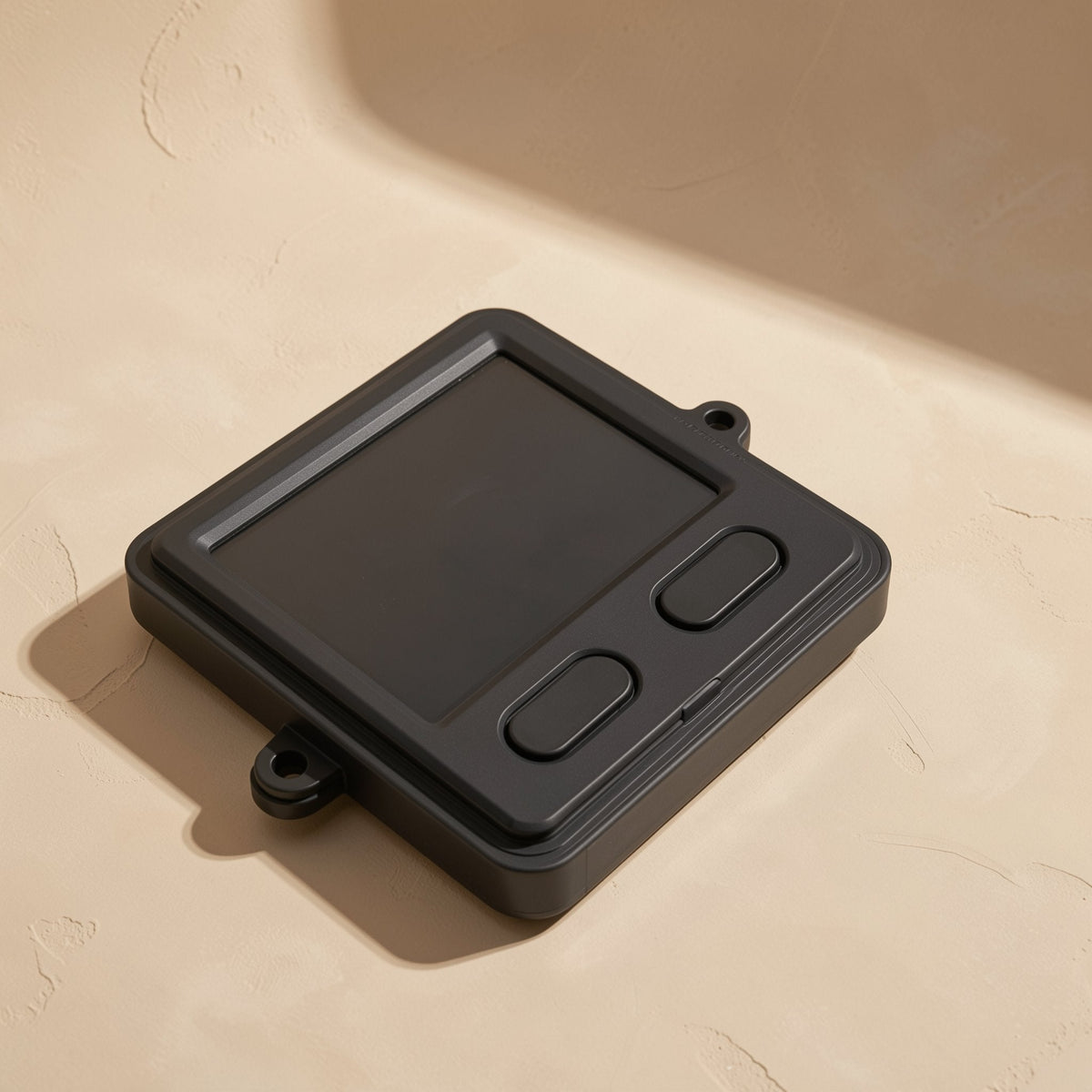 Workclick – Angled view of black touchpad mouse showing square pad, two oval buttons and mounting tab on a beige surface