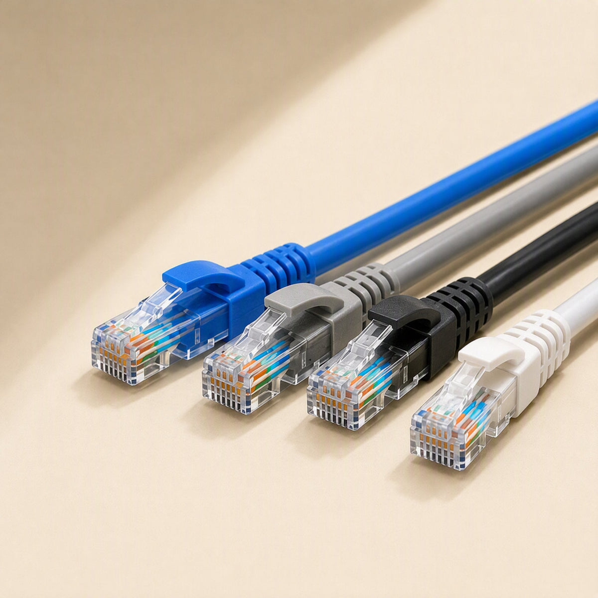Linkpath – Close-up of four colored cable ends with RJ-45 connectors and visible twisted wires on a cream surface