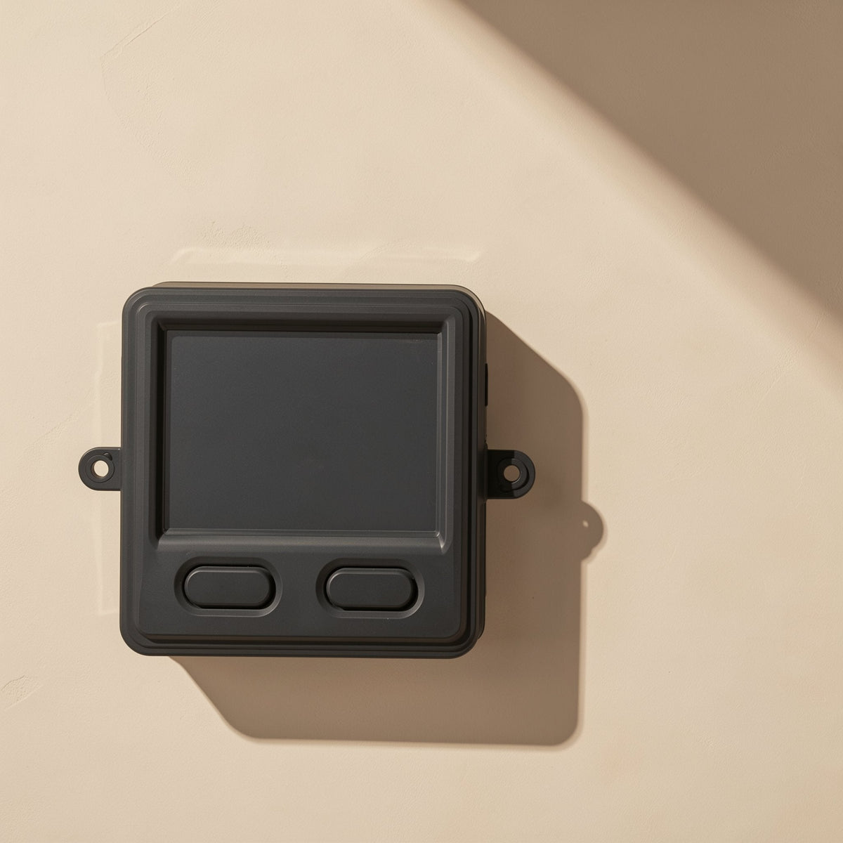 Twinorbit – Top-down view of a black trackball mouse unit with a flat dark pad and two oval buttons, mounting loops at the