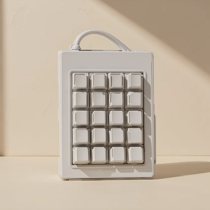 Twinorbit Double-Ring Trackball Mouse – white 20-key grid keypad with attached cable, standing upright against a cream wall