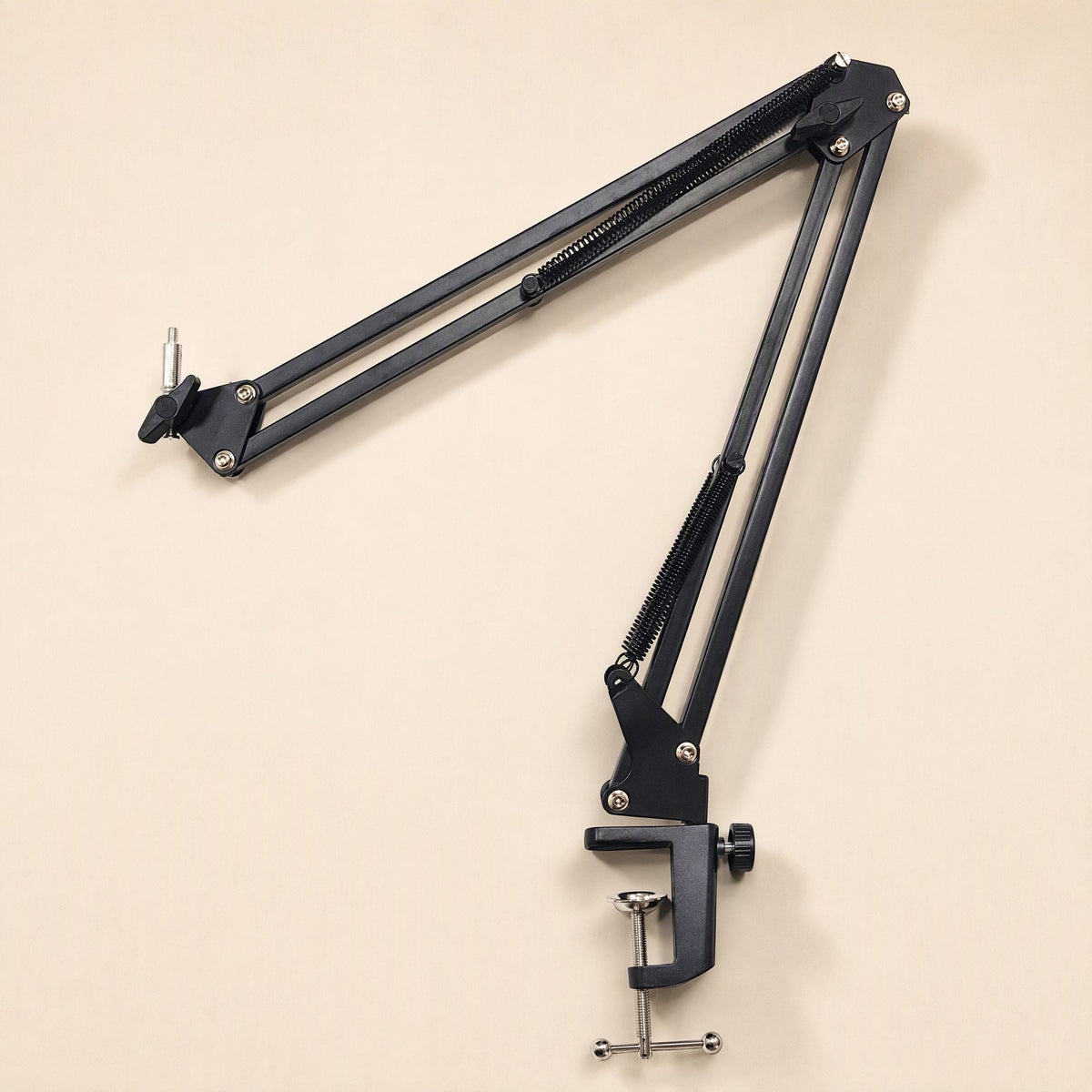 Streamreach – Black cantilever arm folded and angled, showing exposed springs and the desk clamp at the base