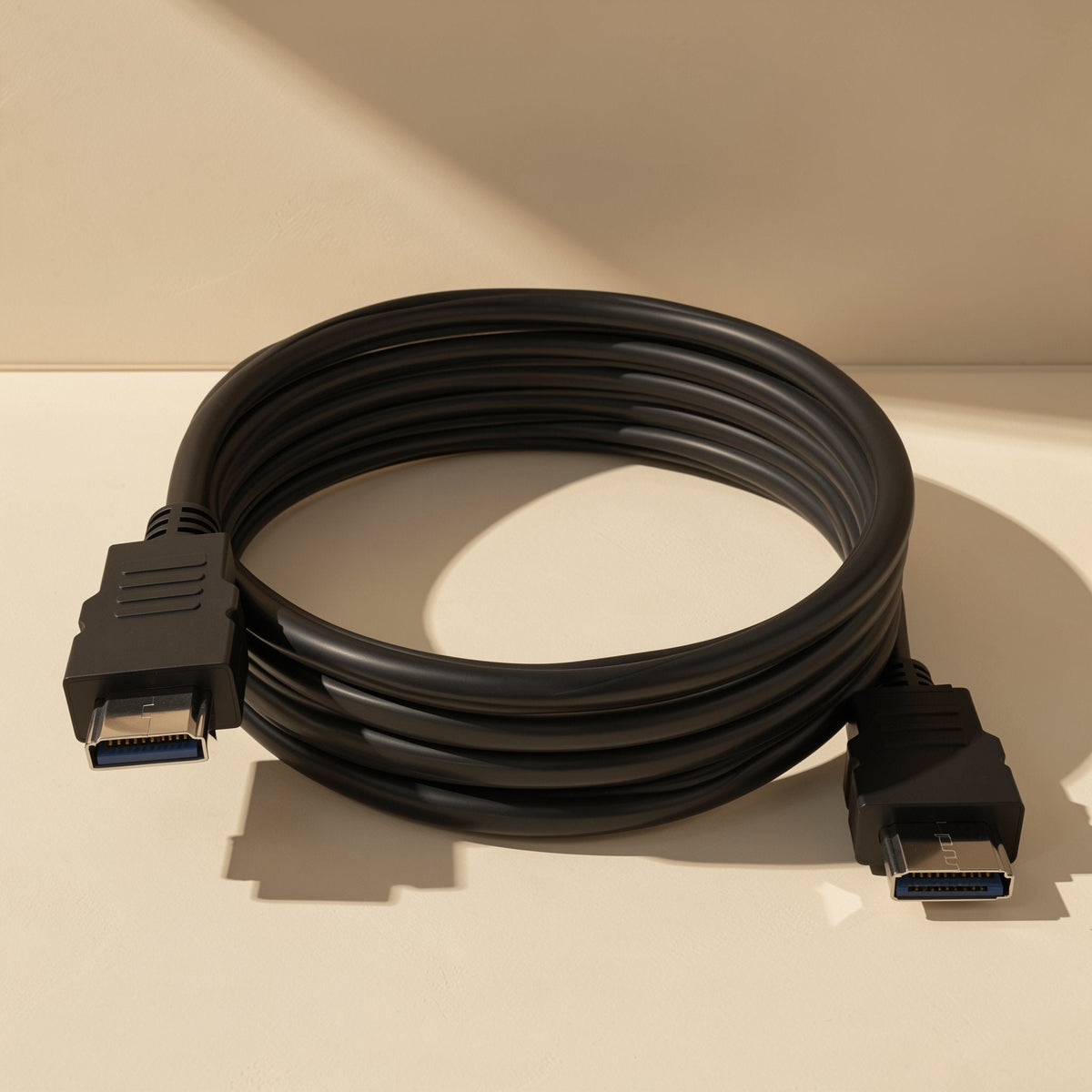 Linkcord – Black HDMI cable coiled flat on a cream surface with both connectors visible and a cast shadow