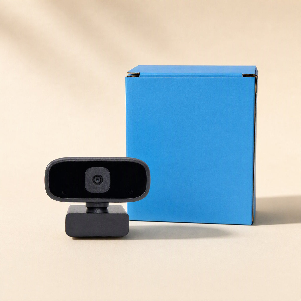 Voiceview – Black webcam standing beside a bright blue product box against a beige backdrop