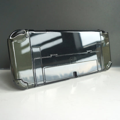 Frameclad – Back of a smoke-grey transparent case on a console, shown at an angle with the kickstand cutout visible