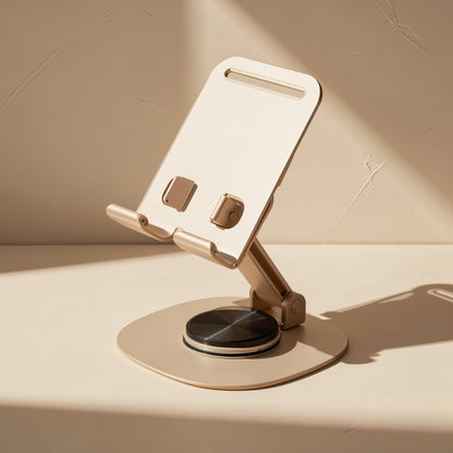 Metalrest – Champagne-gold rotating stand with black swivel disc and adjustable arm, open on a sunlit tabletop