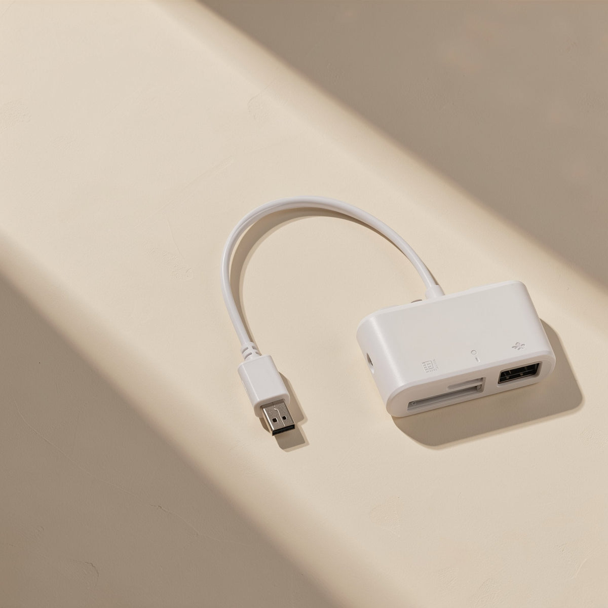 Typehub Type-C SD TF Card Reader with short white cable and USB port, top view in sunlight