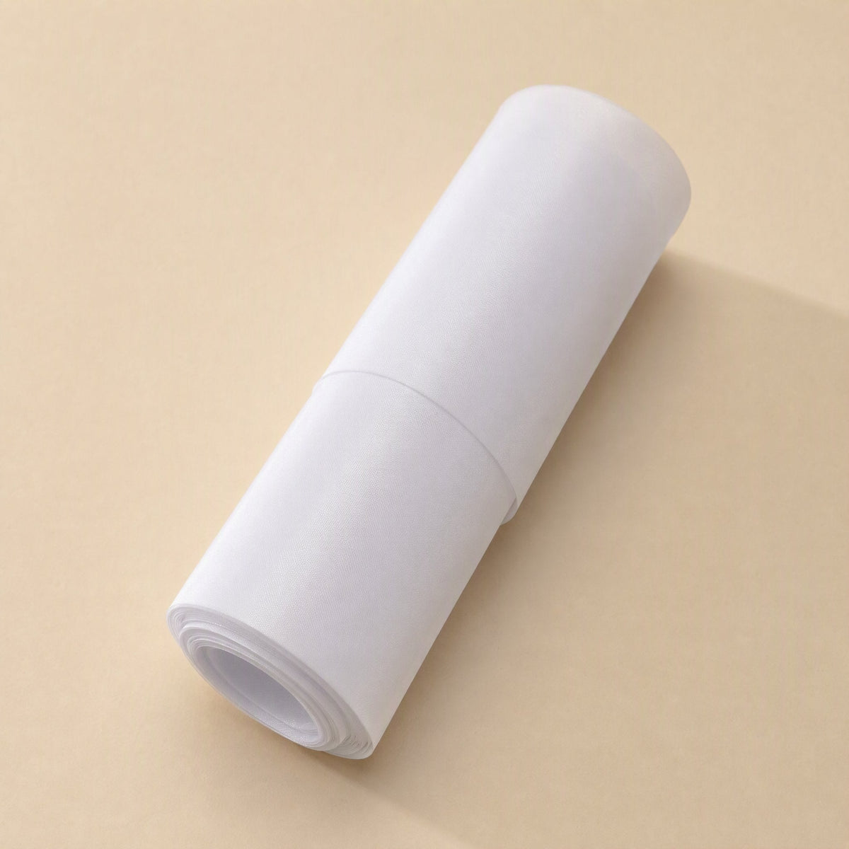 Dustveil Computer Case Dust Net – white paper-wrapped roll of dust net lying diagonally on a beige surface
