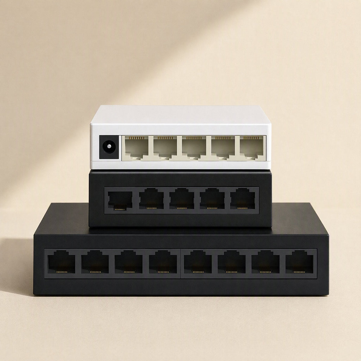 Deskport Desktop Network Switch in white and black, stacked three high, ports facing front