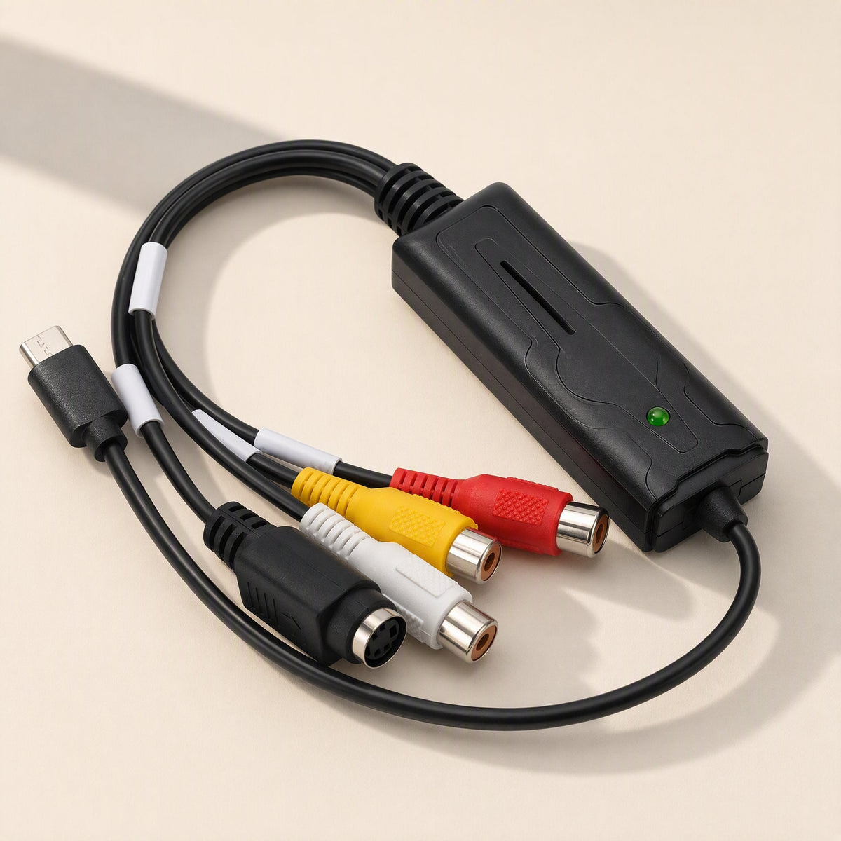 Streamport – Capture card's black housing with green LED, USB-C plug and RCA and S-Video ports, angled left view