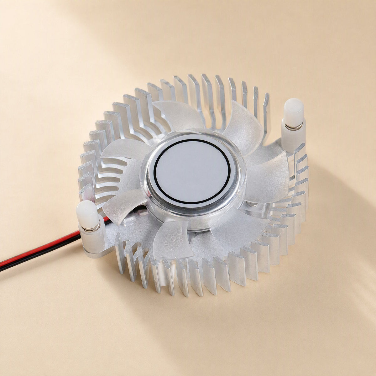 Cardcool – Angled view of the circular finned radiator with fan hub, white pegs and red and black cable