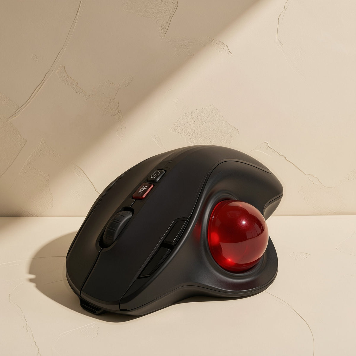 Palmorbit – Black trackball mouse with a glossy red ball, scroll wheel and buttons beside a textured cream wall