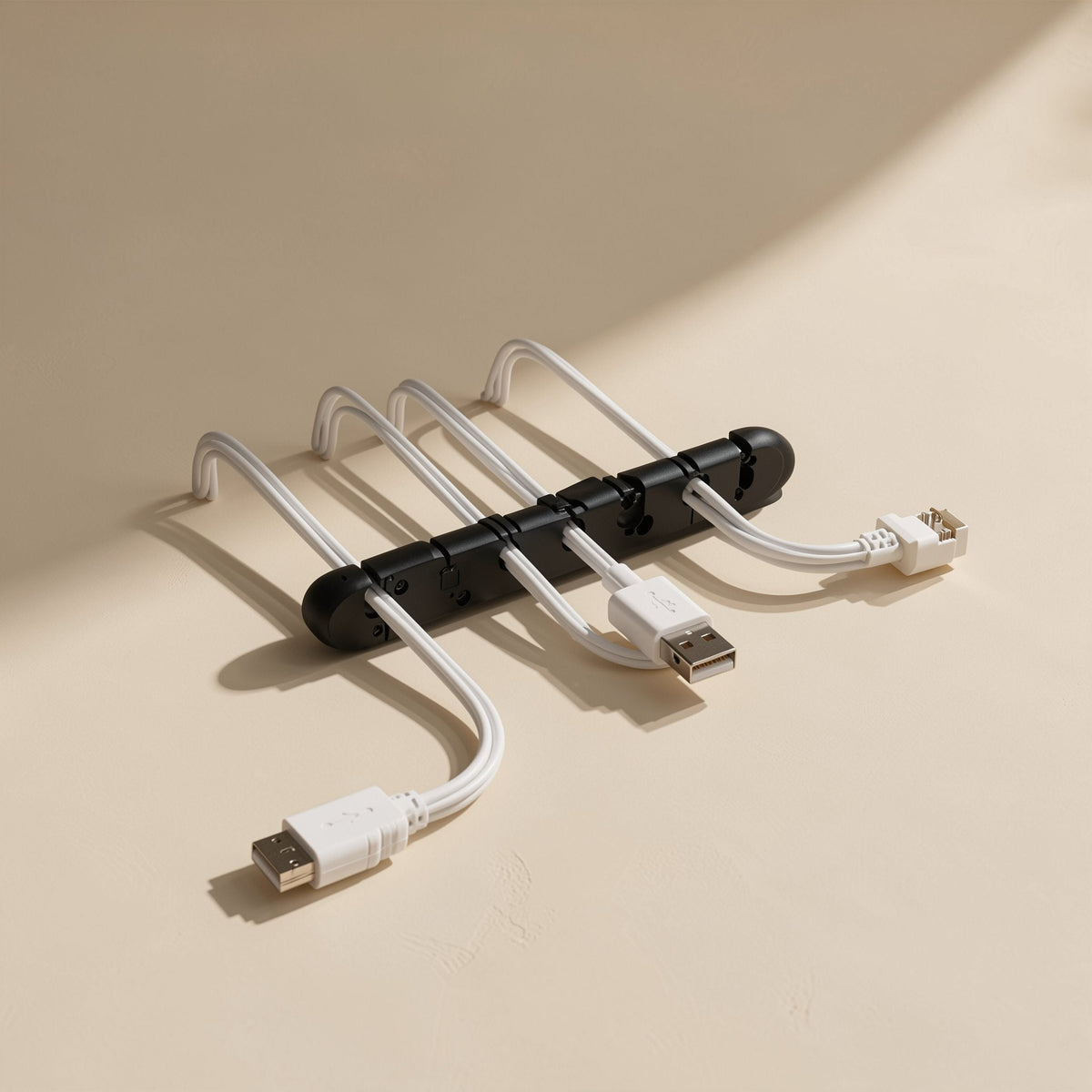 Silinest – Black cable organizer lying flat with four white USB and Ethernet-style cables looping out from its slots