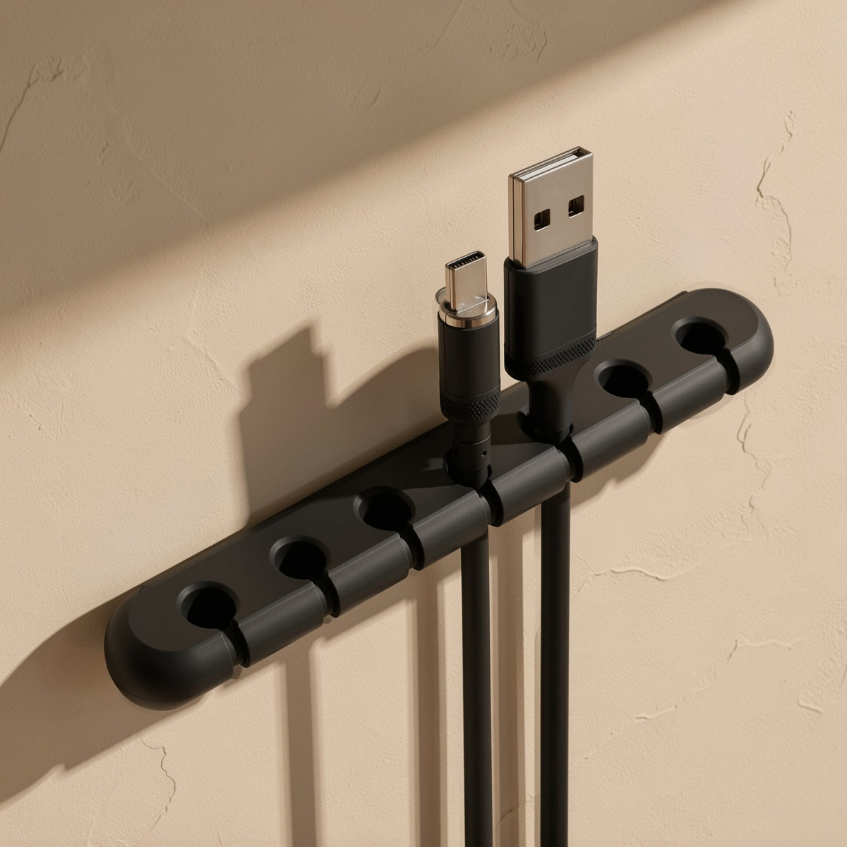 Silinest – Black organizer mounted on a textured beige wall with a micro-USB and a USB-A cable clipped in