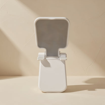 Foldmate – Front view of a white foldable phone stand with a gray cradle and upright base on a beige surface