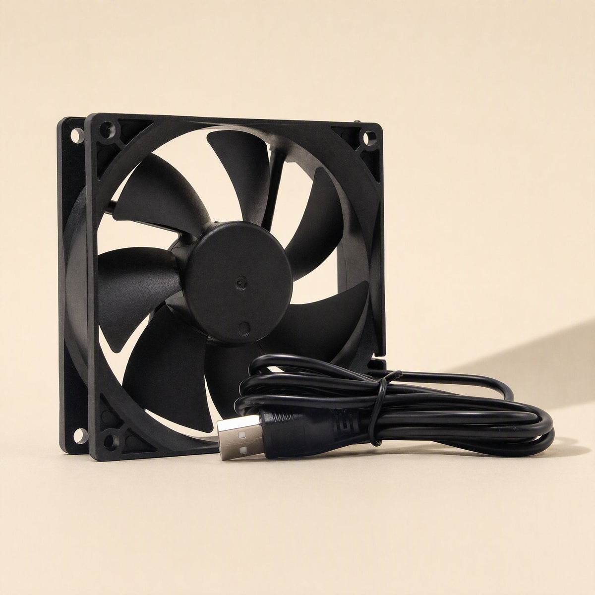 Coolbyte – Fan angled to the left showing seven blades and corner mounting holes, with USB cable coiled at the lower right
