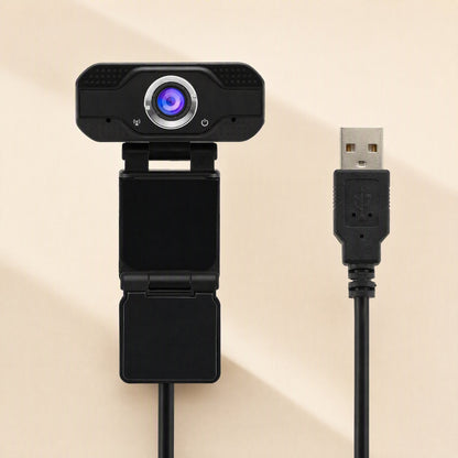 Camclear – Webcam viewed from above with its clip stand folded flat, attached to a black cable ending in a USB plug