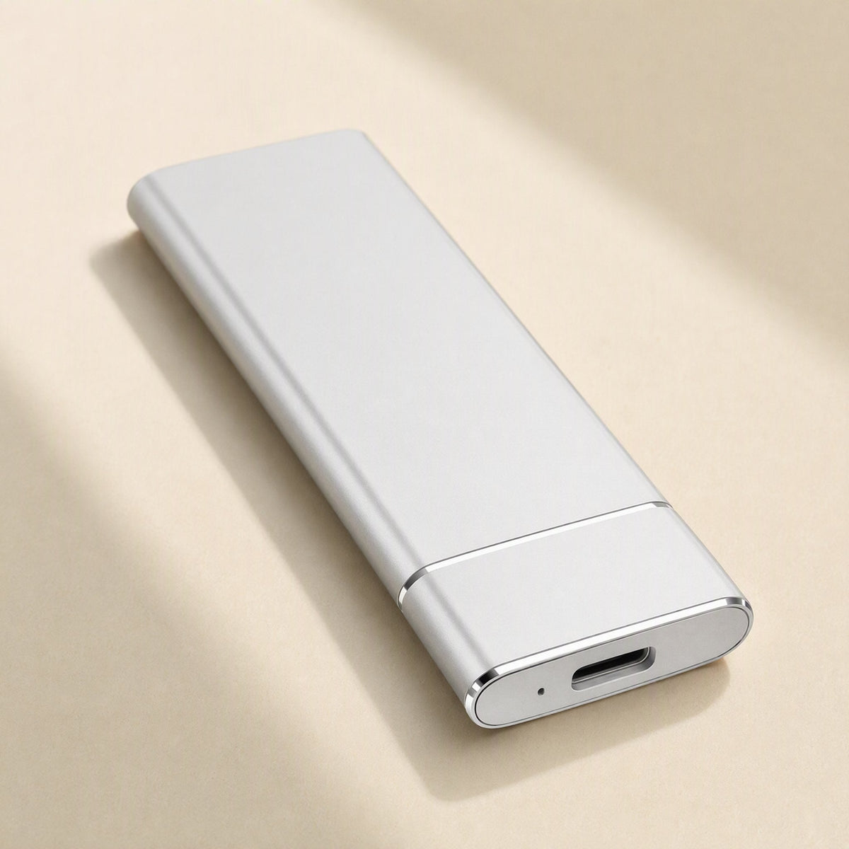 Solidrive – White metal portable SSD lying flat, showing its USB-C port and small indicator light on a cream surface