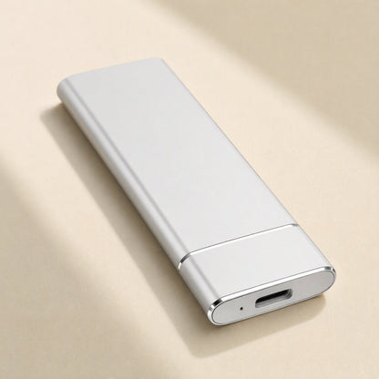 Solidrive – White metal portable SSD lying flat, showing its USB-C port and small indicator light on a cream surface