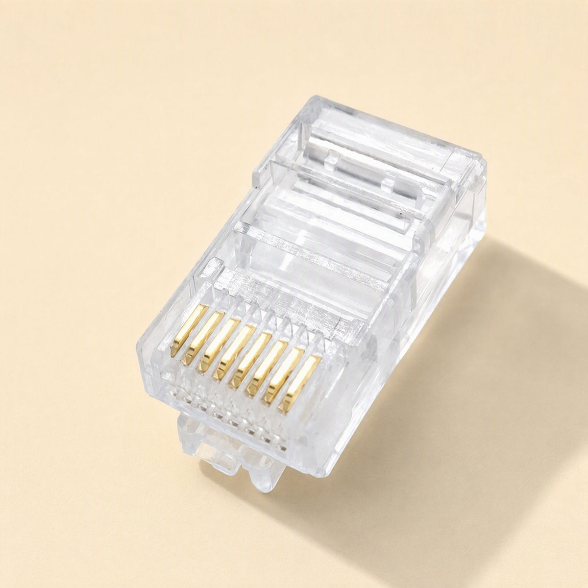 Snaplink – Close-up of a clear RJ45 connector showing eight gold contact pins on a cream background