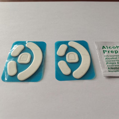 Skimfoot Mouse Foot Stickers: two white Teflon sets on blue backing beside an alcohol prep pad