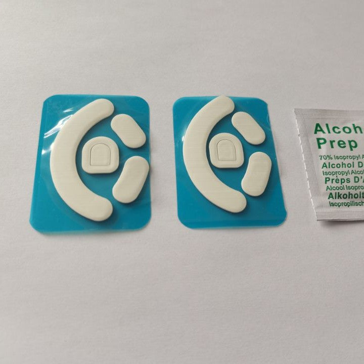 Skimfoot Mouse Foot Stickers – two sets of white curved mouse feet on blue film, shown with an alcohol prep pad on the right
