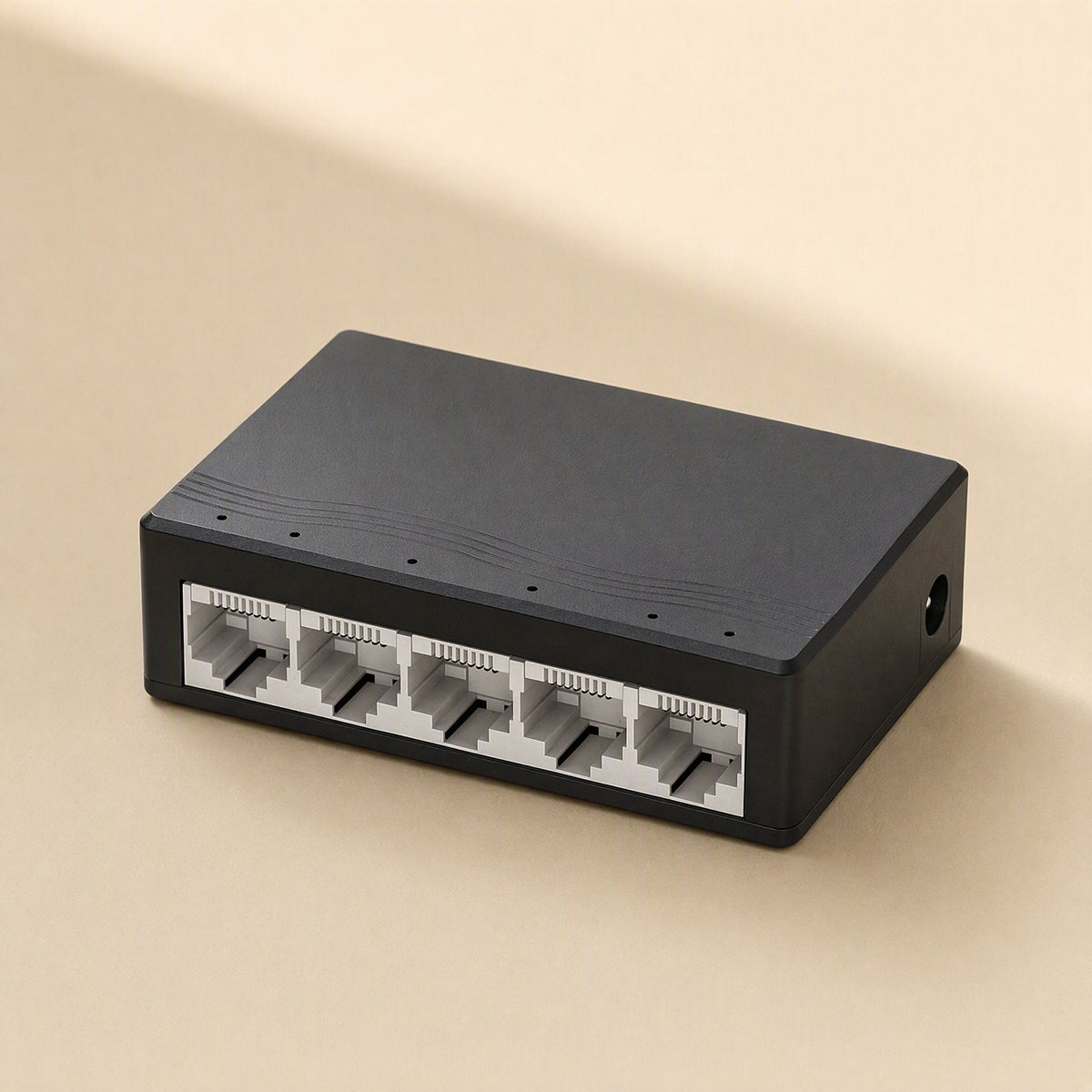 Fiveflow – Black compact switch from the front showing five Ethernet ports and a power jack on the side