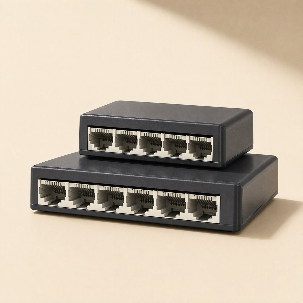 Fiveflow – Small five-port switch stacked on a larger six-port black switch, front view on a beige background