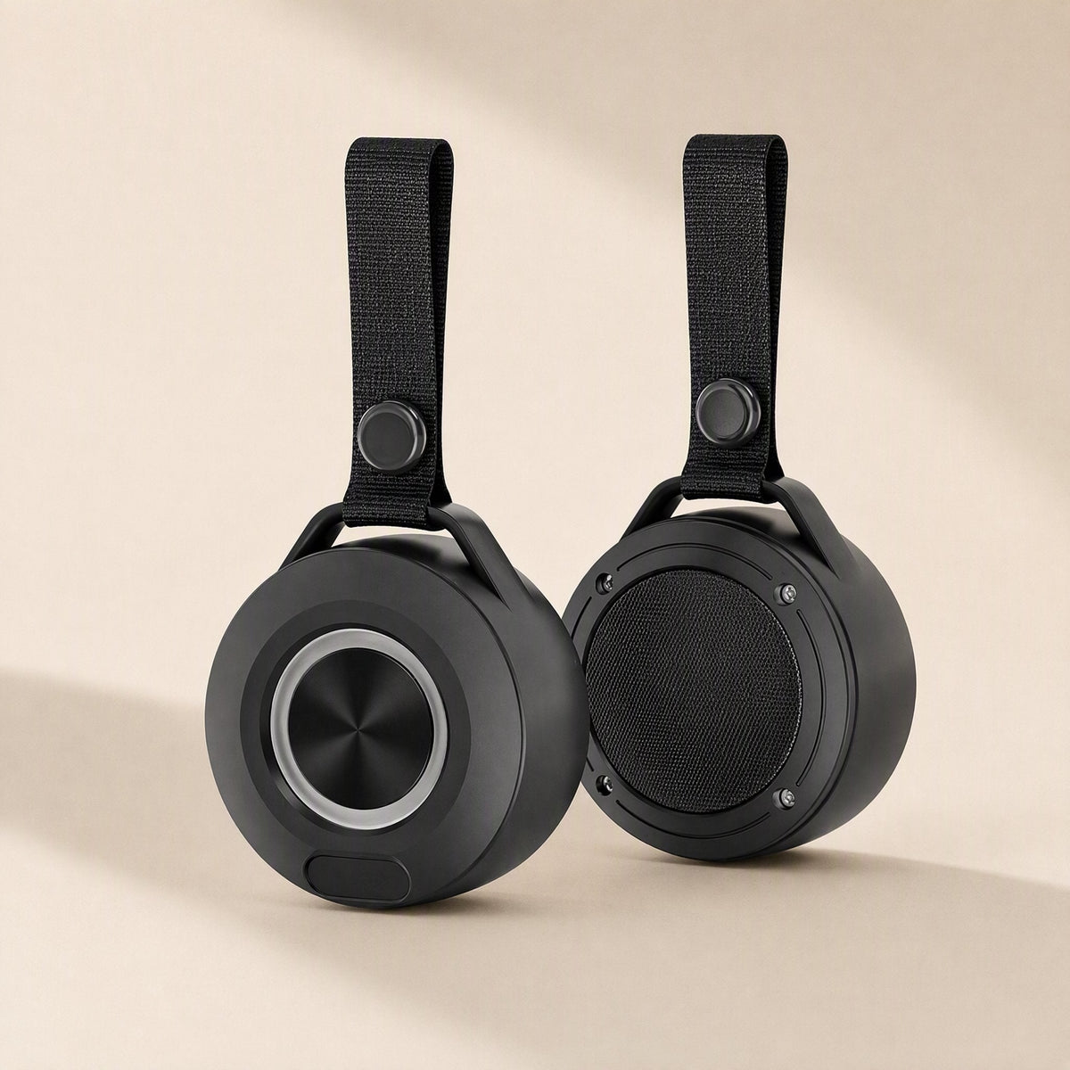 Minibeat – Pair of black speakers with fabric loop straps, one showing the front ring and one showing the mesh back