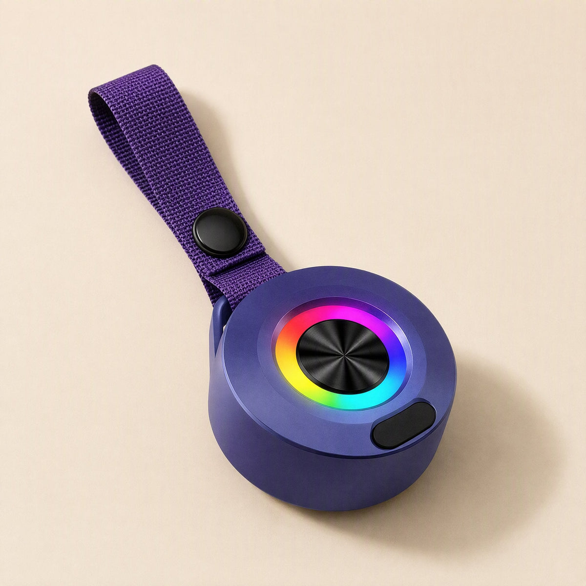 Minibeat – Purple speaker lying flat with a multicolour LED ring around the black center and a purple strap with snap button