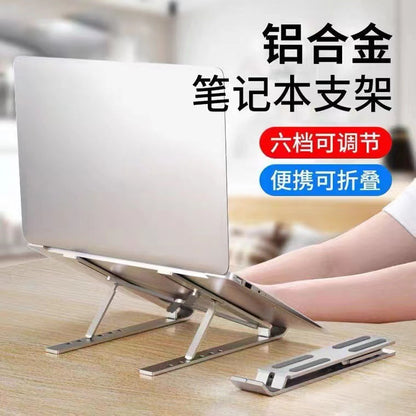 Coolperch – Silver laptop stand holding a laptop on a wooden desk, with a second folded stand lying beside it