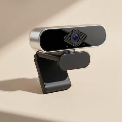 Camvoice USB computer camera with built-in microphone, silver and black, angled front view on a beige surface