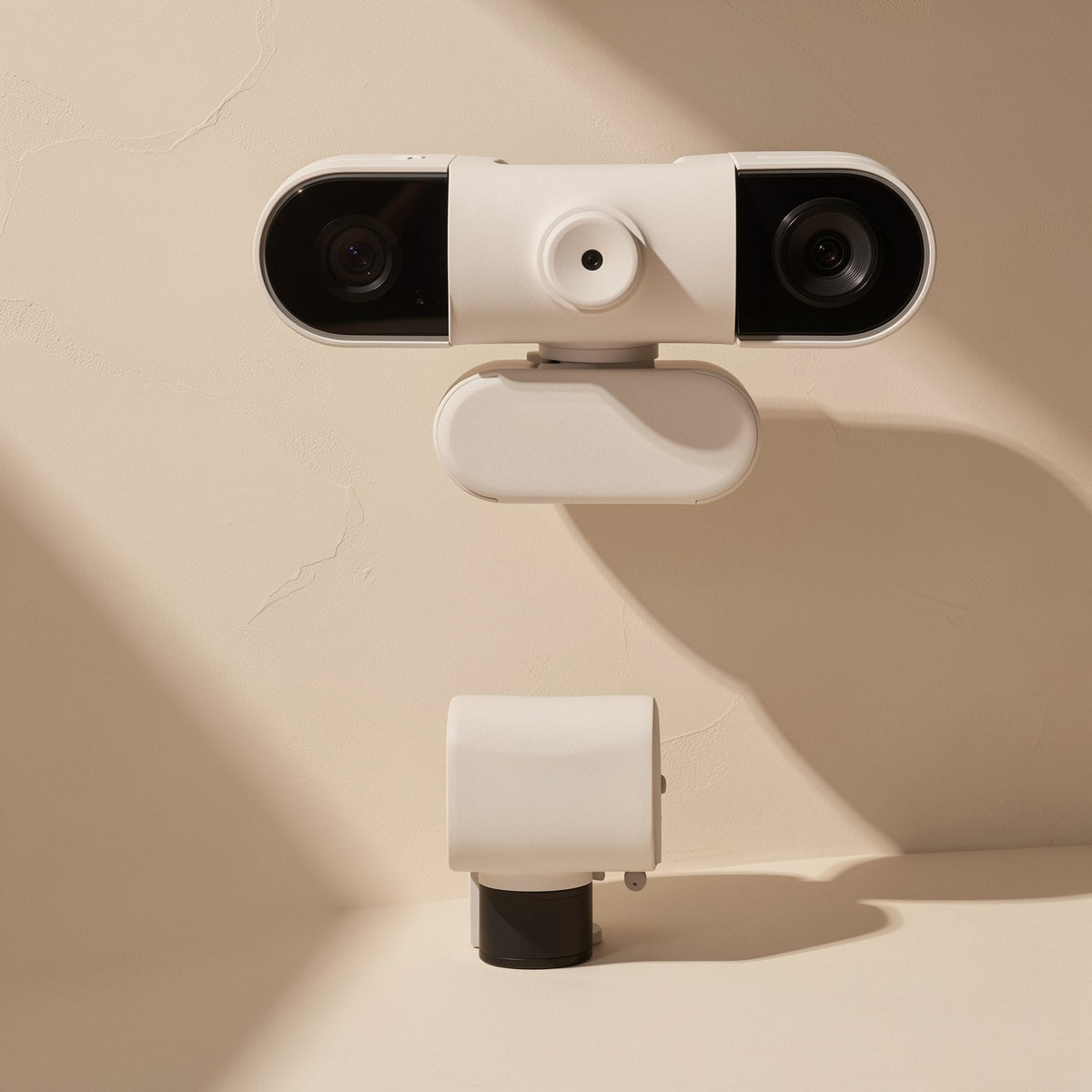Camvoice – Two white camera units, one dual-lens and one small boxy model, against a cream wall with soft shadows