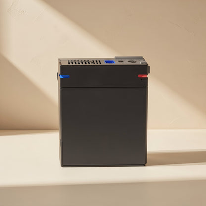 Drivestow – Front view of the black box showing top vents, a blue USB port and a power connector in warm light