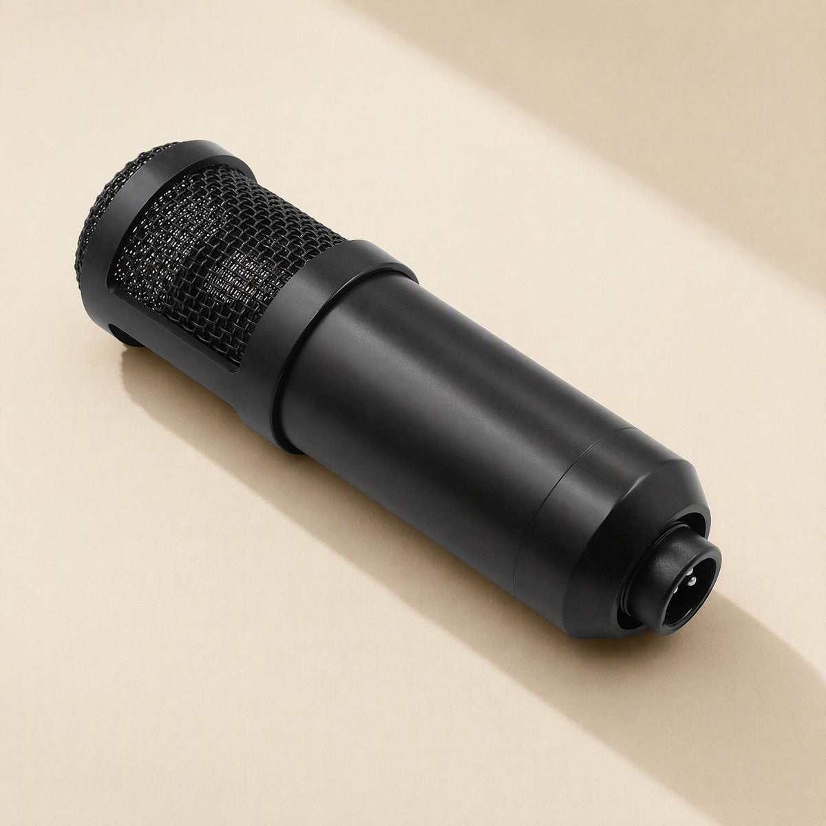 Micshine – Close-up of the black cylindrical microphone body lying on its side, showing the mesh grille and XLR connector