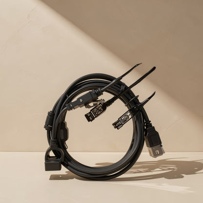 Cordreach – Coiled black cable with several black connectors and plugs, standing upright against a cream wall