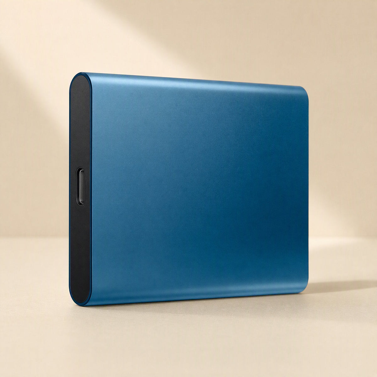 Slimstore – Blue metal-shell drive shown at an angle with a USB-C port on the dark end, in soft window light