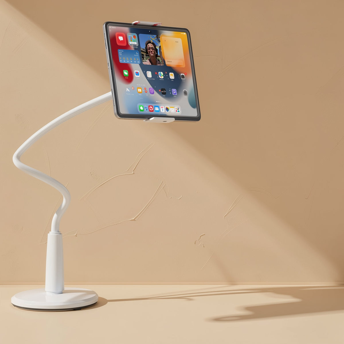 Tiltprop Adjustable Mobile Phone Stand – white flexible stand on a round base holding a tablet that shows an app home screen
