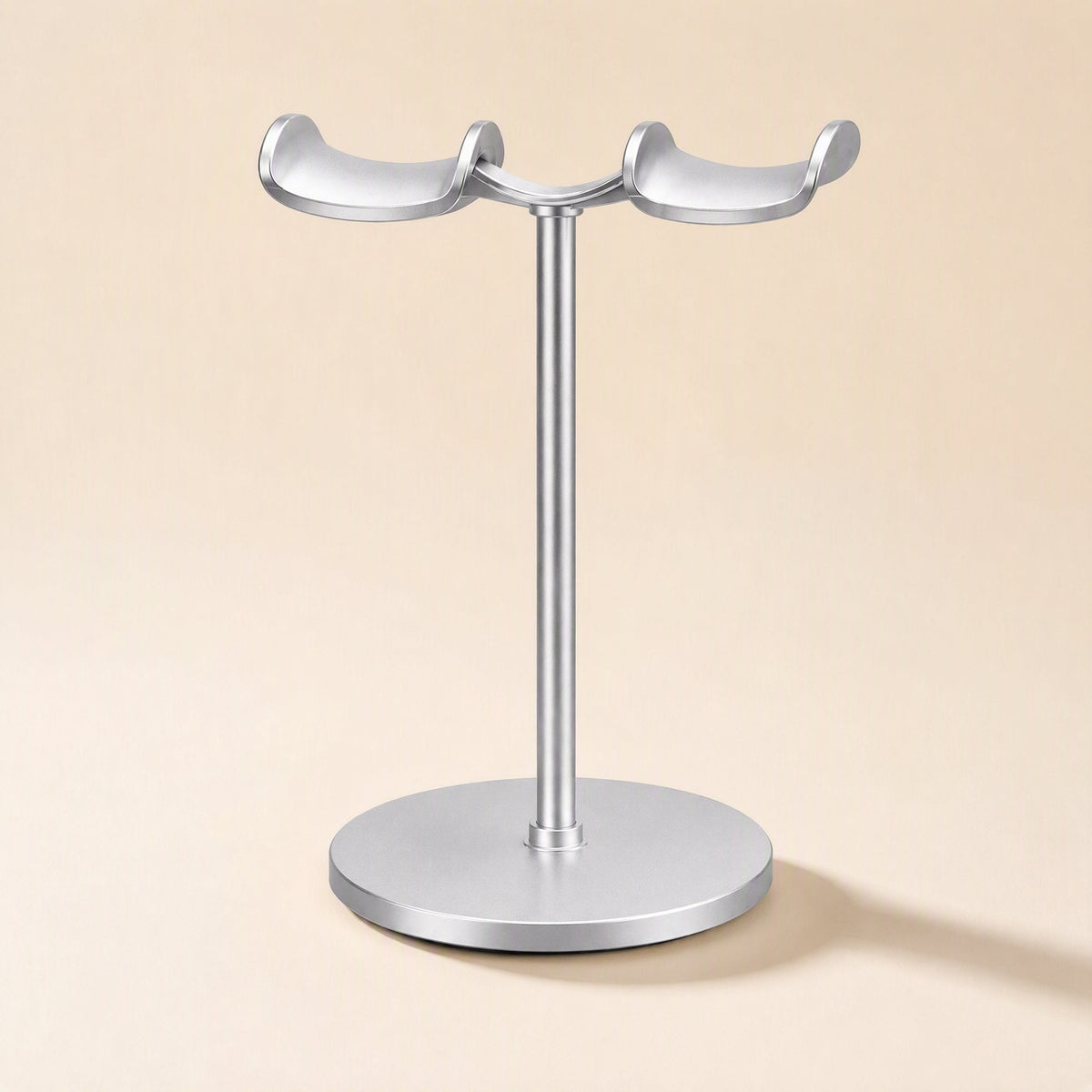 Twinrack – Silver dual-arm headphone stand with a curved bridge between cradles, shown empty on a plain background