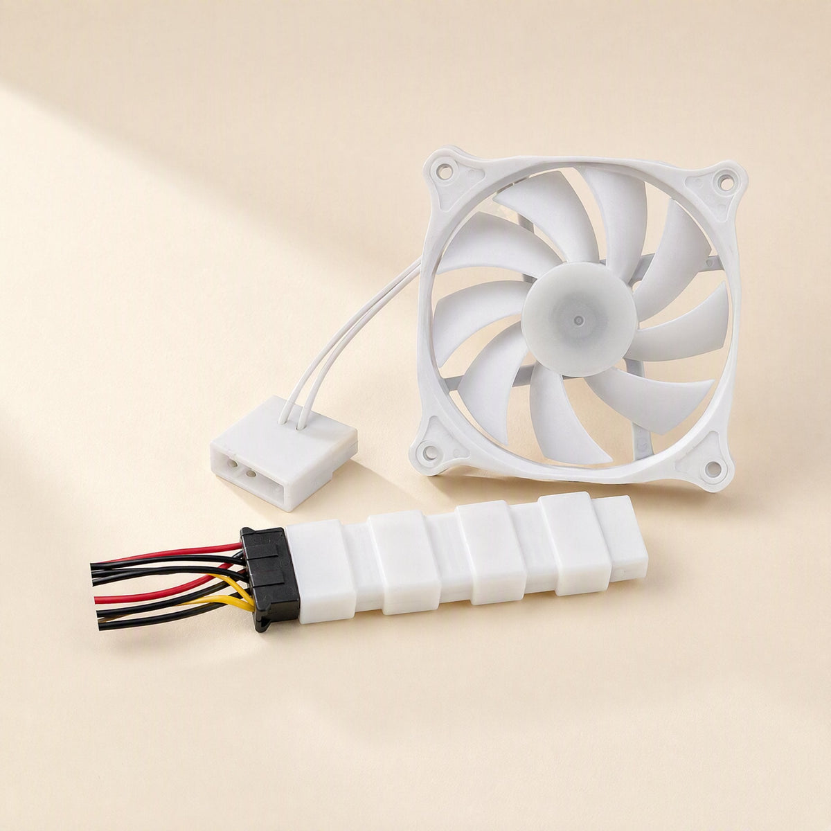 Deskwhirl – White fan with curved blades, attached cable, and a 4-pin Molex adapter lying beside it on a cream surface
